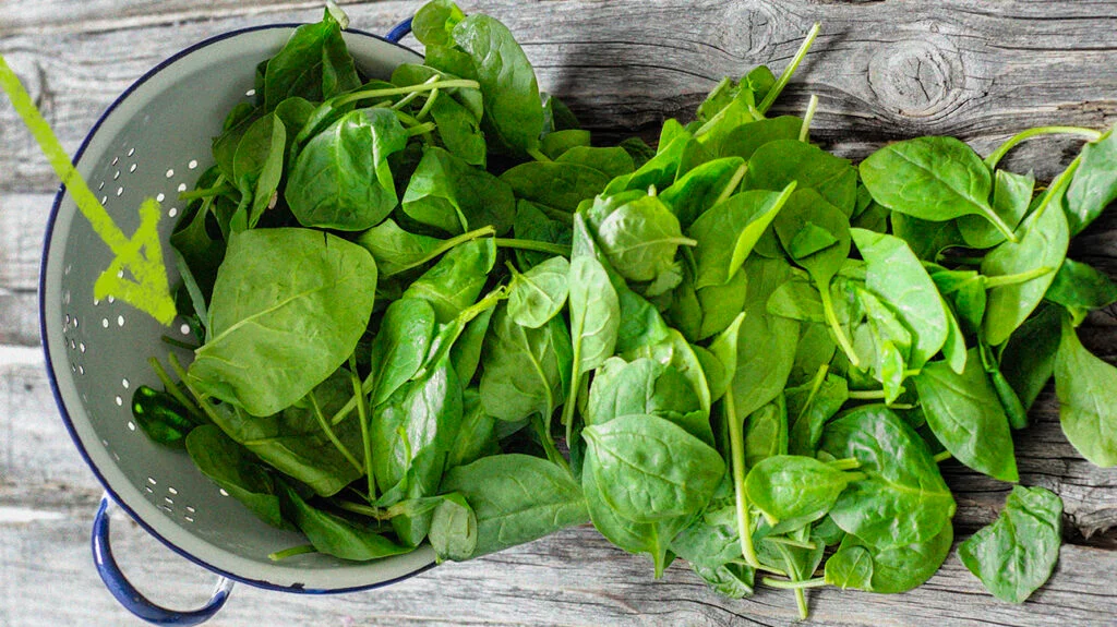 a bowl full of spinach that are falling down