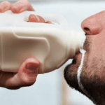 a male drinking milk from a bottle