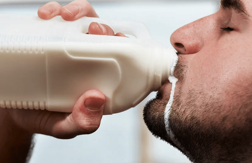 a male drinking milk from a bottle